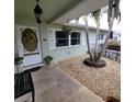 Front porch entry with white door, potted plants, and a small bench at 568 Seacrest Dr, Largo, FL 33771