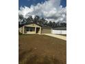 Tan house with gray garage door and solar panels at 8303 Begonia St, Spring Hill, FL 34608