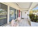 Relaxing front porch with pink chairs and tiled flooring at 9548 141St St, Seminole, FL 33776