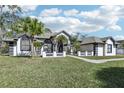 White and gray house with palm trees and a green lawn at 1010 Emerald Creek Dr, Valrico, FL 33596