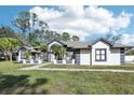 Two-story house with grey accents, lush lawn, and palm trees at 1010 Emerald Creek Dr, Valrico, FL 33596