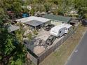 Aerial view of the property with a large parking area, car port, and fenced in yard at 1215 E Holland Ave, Tampa, FL 33612