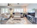 Bright living room featuring a neutral color scheme, comfy furniture, and a large TV at 12391 70Th St, Largo, FL 33773