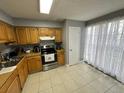 Cozy kitchen featuring wood cabinets, stainless steel appliances, and tile floor at 13909 Fletchers Mill Dr, Tampa, FL 33613