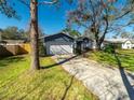 Well-maintained home with a driveway, and a lush green lawn at 15716 Country Lake Dr, Tampa, FL 33624