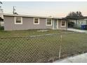 Exterior view of a quaint home with a chain-linked fence at 1804 Cadillac Cir, Tampa, FL 33619