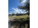 This exterior shot shows the house and yard, showcasing its well-kept lawn and inviting curb appeal at 22065 Malone Ave, Port Charlotte, FL 33952