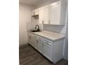 Renovated kitchen with white shaker cabinets and gray vinyl flooring at 2421 19Th S St, St Petersburg, FL 33712