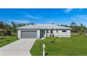 Aerial view of a single-story house with gray garage doors and a mailbox at 25434 Alicante Dr, Punta Gorda, FL 33955