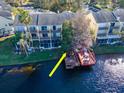 Scenic backyard view with a wooden dock extending onto a tranquil lake and screened patio at 2648 Sabal Springs Dr # 2, Clearwater, FL 33761