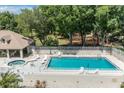 Community pool and spa with lounge chairs at 2824 Countryside Blvd # 326, Clearwater, FL 33761