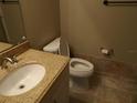 Bathroom with granite countertop, toilet, and sink at 3300 Cove Cay Dr # 6G, Clearwater, FL 33760