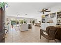 Open-concept living area with tile floors, built-in bookshelves, and views of the pool at 3310 Carib Rd, Tampa, FL 33618