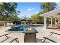 Inviting backyard pool area with lounge chairs and a modern fire pit for entertaining at 3310 Carib Rd, Tampa, FL 33618