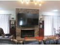 Spacious living room with a large TV and stone fireplace at 3829 Biscay Pl, Land O Lakes, FL 34639