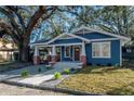 Newly renovated home with blue exterior, landscaping, and a large front yard at 409 E Adalee St, Tampa, FL 33603