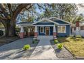 Renovated blue house with a walkway, landscaping, and a spacious front yard at 409 E Adalee St, Tampa, FL 33603