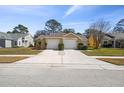 A wide view of the front exterior with a shared driveway and attached garages at 4210 Revere Cir, New Port Richey, FL 34653