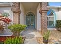 Close up of a charming front entrance with a beautiful blue double door and brick pillar accents at 4833 Yellowstone Dr, New Port Richey, FL 34655