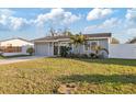 Attractive single-story home featuring well-kept landscaping, a driveway, and a white privacy fence at 5864 Mckee Lake N Dr, St Petersburg, FL 33709