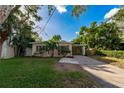 Charming single-story home with a well-maintained lawn and covered carport at 664 Geneva Pl, Tampa, FL 33606