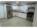 Renovated kitchen, featuring stainless steel appliances and white cabinets at 8014 N Alaska St, Tampa, FL 33604