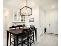 Bright dining room featuring modern lighting, dark wood table, and built in bar with glass cabinets at 8463 Canyon Creek Trl, Parrish, FL 34219