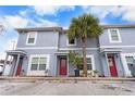 Front view of a light blue triplex with red doors at 9206 Bella Terraza Way, Temple Terrace, FL 33617