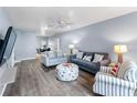 Living room with gray couches, striped chairs, and wood floors at 9206 Bella Terraza Way, Temple Terrace, FL 33617