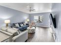 Living room with gray couches, striped chairs, and wood floors at 9206 Bella Terraza Way, Temple Terrace, FL 33617