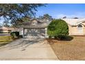 Single-story home with a two-car garage and lush landscaping at 9287 New Orleans Dr, Weeki Wachee, FL 34613