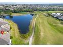 Aerial view showcasing the property's location on a golf course with nearby water and golf cart path at 970 Pembroke Point Way, Sun City Center, FL 33573