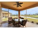 Enclosed patio with ceiling fan featuring comfortable seating and a view of the serene lake at 970 Pembroke Point Way, Sun City Center, FL 33573