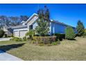 House exterior showcasing landscaping and a three-car garage at 13903 Natures Reserve Dr, Lithia, FL 33547