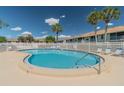 Community pool with surrounding patio furniture and white fence at 223 Sun Vista S Ct, Treasure Island, FL 33706