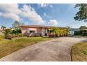 Front view of a ranch home with palm trees and a curved driveway at 2351 Leslee Lake N Dr, St Petersburg, FL 33713