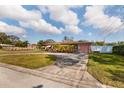 Pink house with a large yard and a long driveway at 2351 Leslee Lake N Dr, St Petersburg, FL 33713