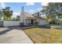 House exterior view, featuring a white facade, two-car garage, and a spacious front yard at 3118 W Hartnett Ave, Tampa, FL 33611