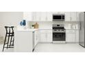 Modern kitchen featuring stainless steel appliances and white cabinetry at 5190 Meyer Bessie St, Zephyrhills, FL 33541