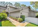 Tan home with walkway, landscaping, and two car garage at 5340 Cobblestone Ct, Wesley Chapel, FL 33543