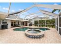 Relaxing backyard with a screened-in pool, spa, and brick-paved patio at 13001 Prestwick Dr, Riverview, FL 33579