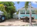 Outdoor patio with seating area, grill, and tropical landscaping at 13405 Gulf Blvd, Madeira Beach, FL 33708