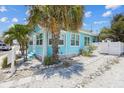 Charming light blue house with landscaping and walkway at 13405 Gulf Blvd, Madeira Beach, FL 33708