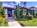 A secure gated entryway with a stone facade, surrounded by lush greenery, and a pristine lawn at 200 Brightwaters Ne Blvd, St Petersburg, FL 33704