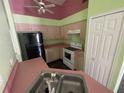 Kitchen with pink countertops, white cabinets, and black appliances at 2226 Ridgemore Dr, Valrico, FL 33594