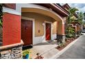 Exterior view of two condo building entrances with red doors and stone accents at 2245 Chianti Pl # 718, Palm Harbor, FL 34683