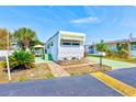 Front view of a white mobile home with patio furniture and tropical plants at 27466 Us Highway 19 N # 54, Clearwater, FL 33761