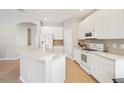 White kitchen featuring modern appliances, ample counter space, and tiled flooring at 2813 Punta Palma Ct, Holiday, FL 34691