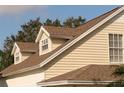 Close-up of the home's exterior, highlighting the roof line, dormer window, and light yellow siding at 5607 Tanagergrove Way, Lithia, FL 33547