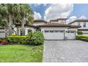 Two-story house with tile roof, three-car garage, and landscaped yard at 6648 Sunset Vista Way, Land O Lakes, FL 34637